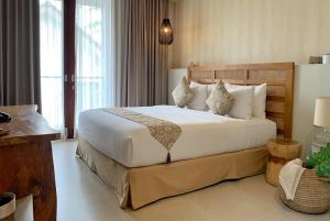 a bedroom with a large bed with white sheets and pillows at Umah Tirta Estate in Ubud +58 photos
