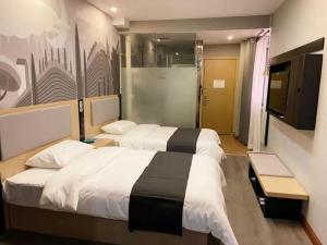a hotel room with two beds and a flat screen tv at Thank Inn Chain Hotel hebei langfang gymnasium in Langfang