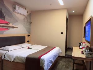 a bedroom with a bed and a desk and a tv at Thank Inn Chain Hotel henan zhengzhou xinzheng city north china road xuanyuan lake in Zhengzhou