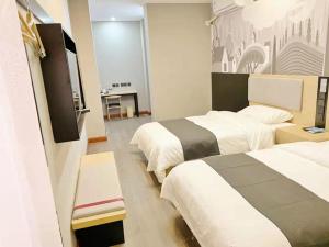 a hotel room with two beds and a flat screen tv at Thank Inn Chain Hotel hebei langfang gymnasium in Langfang