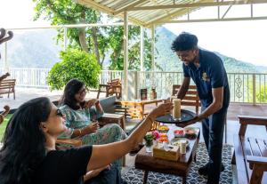 a man giving a woman a plate of food at Neer Ganga Resorts in Rishīkesh