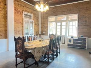 a dining room with a table with chairs and a chandelier at Walauwa on the hill in Hatton