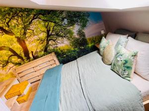 una camera da letto con un letto e un dipinto sul muro di Bed § Boutique du Lapin Vert ad Anthisnes