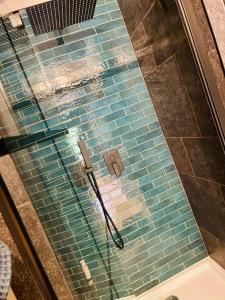 uma cabina de duche em vidro com um chuveiro na casa de banho em Bed § Boutique du Lapin Vert em Anthisnes