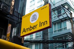 a yellow and red sign on the side of a building at Amber Inn in Bangkok