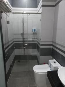 een badkamer met een douche, een toilet en een wastafel bij Garden House Côn Đảo in Con Dao