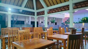 an empty restaurant with wooden tables and chairs at THE LAVIANA HOTEL in Lovina