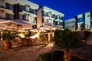 een patio met tafels en parasols voor een gebouw bij Seaside Garden 2 Bedroom Apartment For 41 Pax in Sunny Beach