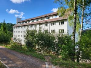 een wit gebouw aan de kant van een weg bij Werrapark Aktiv Hotel Am Sommerberg in Masserberg