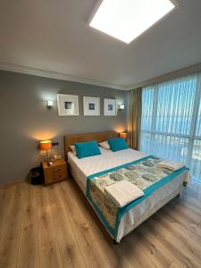 um quarto com uma cama grande e almofadas azuis em Basoglu Bulancak Hotel em Bulancak