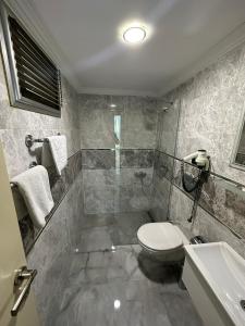 y baño con ducha, aseo y lavamanos. en Basoglu Bulancak Hotel, en Bulancak