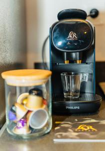 une cafetière assise sur un comptoir avec un récipient en verre dans l'établissement Nid douillet La Cour du Dauphin, Vue cathédrale imprenable, à Laon