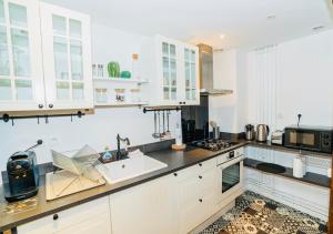 a kitchen with white cabinets and a sink at Nid douillet La Cour du Dauphin, Vue cathédrale imprenable in Laon