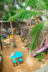 a beach with tables and chairs and palm trees at Oynise Beach Cabin in Galle