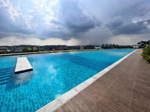 una gran piscina azul con un cielo nublado en Condostay at Bangi, en Kampong Sungai Ramal Dalam