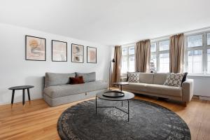 a living room with a couch and a table at Sanders Regent - Treasured Three-Bedroom Apartment Near Central Square in Copenhagen
