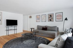 a living room with a couch and a tv at Sanders Regent - Treasured Three-Bedroom Apartment Near Central Square in Copenhagen