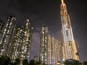a tall building with lights in a city at night at Landmark Plus Luxury - Vinhomes Central Park in Ho Chi Minh City