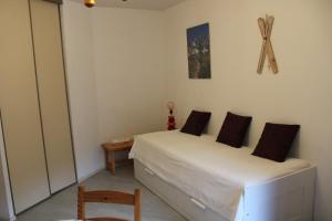 a small bedroom with a bed and a chair at Les Pierres Blanches Contamines Montjoie in Les Contamines-Montjoie