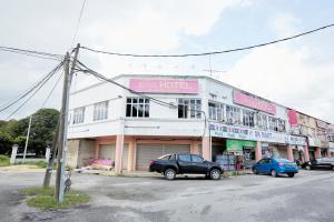 JertihJerteh Hotel, Terengganu的前面停着汽车的建筑物