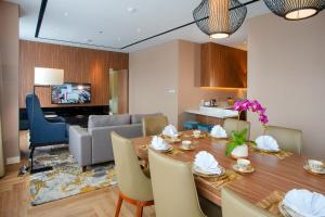 巴東的住宿－The ZHM Premiere Padang，用餐室以及带桌椅的起居室。