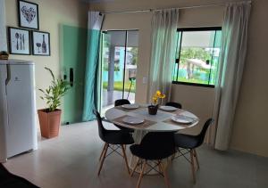 een witte tafel en stoelen in een kamer met een raam bij Kit Dona Branca in Alto Paraíso de Goiás