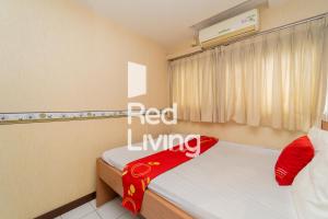 - une chambre avec 2 lits et un panneau rouge dans l'établissement Apartemen Sentra Timur Residence - S&A Zada Property Tower Orange, à Jakarta