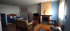サント・トメ・デル・プエルトにあるApartamentos Turísticos La Casa de Dafneのリビングルーム(ベッド1台、暖炉付)