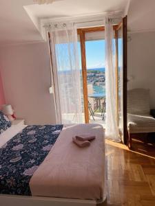 1 dormitorio con cama y ventana grande en Sunset Rooms Dubrovnik, en Dubrovnik