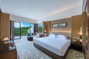 um quarto com uma cama grande e uma sala de estar em Mission Hills Hotel Resorts Dongguan em Dongguan