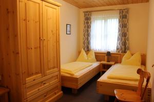 a bedroom with two twin beds and a window at Bio-Bauernhof Vordergrubenbach - Familie Oberascher in Hintersee