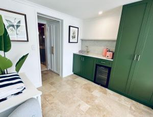 a kitchen with green cabinets and a tile floor at The Boathouse at Whitesands Cronulla in Cronulla