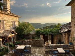 a patio with tables and chairs in a building at Orestis House in Ano Pedina