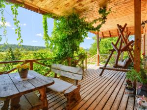 a wooden deck with a table and bench on it at Gościniec Rabe - Agro&SPA in Ustrzyki Dolne