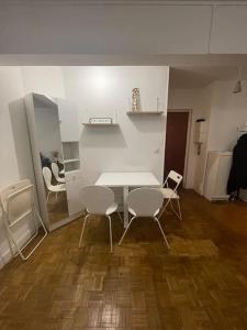 Habitación con mesa blanca y sillas. en 2 pièces Paris Centre, en París