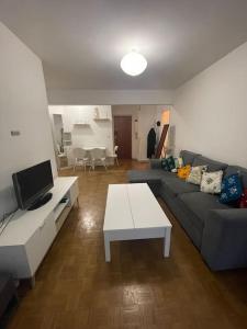 sala de estar con sofá y mesa en 2 pièces Paris Centre, en París