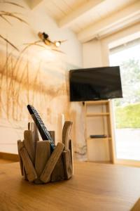 einem Holzmesserhalter auf einem Tisch mit einem TV in der Unterkunft Petite Maison située entre Saint-Malo et Cancale in Saint-Méloir-des-Ondes