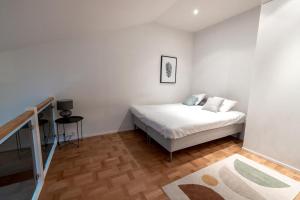 ein weißes Schlafzimmer mit einem Bett und einem Tisch in der Unterkunft 2ndhomes Luminous & Modern 107m2 Penthouse in Kruununhaka in Helsinki