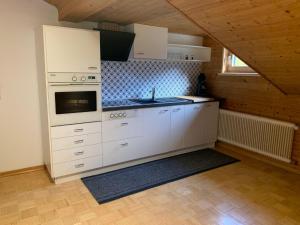 a kitchen with white cabinets and a stove top oven at Haus Angelika in Innerbraz