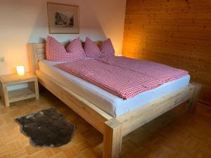 a bedroom with a large bed with red and white pillows at Haus Angelika in Innerbraz