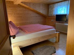 Habitación con cama en una cabaña de madera en Haus Angelika en Innerbraz