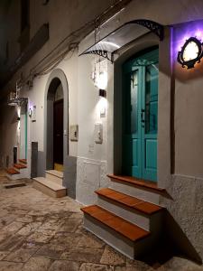 a building with a blue door and some stairs at Vecchia Mottola Albergo Diffuso in Mottola