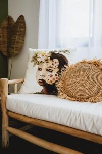 uma máscara sentada numa cama com uma almofada em Villa Couleur Nature em Salazie