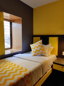 a bedroom with a bed with yellow walls and a window at CABIN STAY-SOCIAL HUBZ in Mumbai