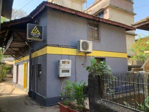 a blue and yellow building with a sign on it at CABIN STAY-SOCIAL HUBZ in Mumbai