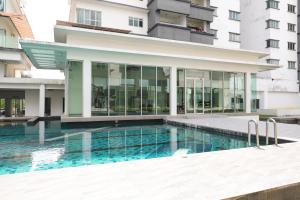 a swimming pool in front of a building at Cozy 2 bedroom w Pool - 6 Pax - Kajang in Kajang