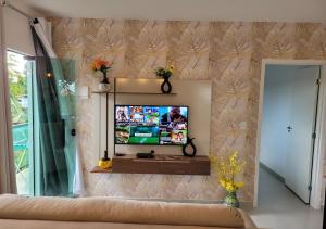 a living room with a flat screen tv on a wall at Kit Dona Branca in Alto Paraíso de Goiás