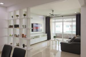 een woonkamer met een bank en een tv bij Cozy 2 bedroom w Pool - 6 Pax - Kajang in Kajang