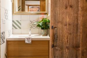 a bathroom with a sink and a mirror at Casele cu Stuf B&B Haus Ulrike in Sălicea