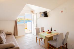 ein Wohnzimmer mit einem Tisch, Stühlen und einem Sofa in der Unterkunft Magdalena with mountain and seaview in Metajna